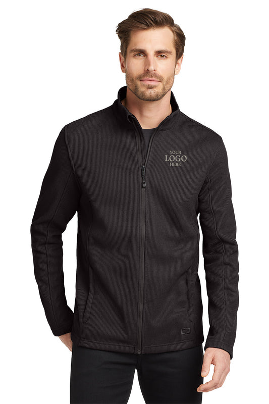 Man wearing a black jacket with 'Your Logo Here' text on a white background embroidered OGIO® Grit Fleece Jacket