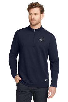 Man wearing a navy blue pullover with a logo on a white background, embroidered OGIO® Luuma 1/2-Zip Fleece