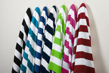 Set of colorful striped beach towels hanging against a plain background. Port Authority® Cabana Stripe Beach Towel, Embroidered by Helmsman Stitch Co.