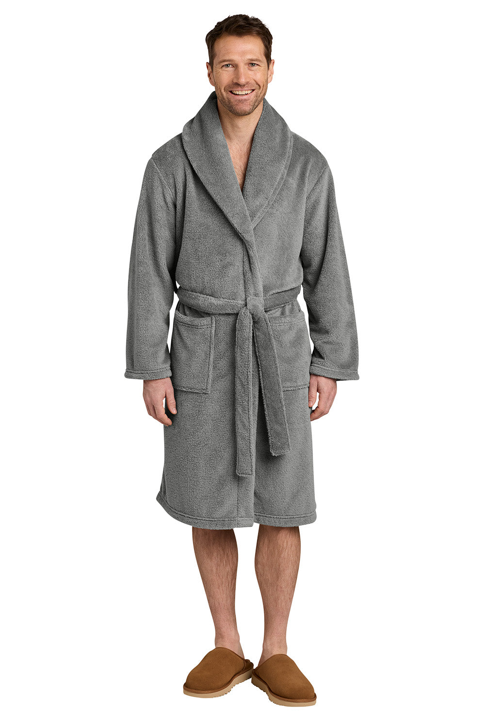 A man wearing a gray plush bathrobe with a shawl collar and tie belt, paired with brown slippers, standing against a plain white background. Port Authority® Dream Plush Robe, Embroidered