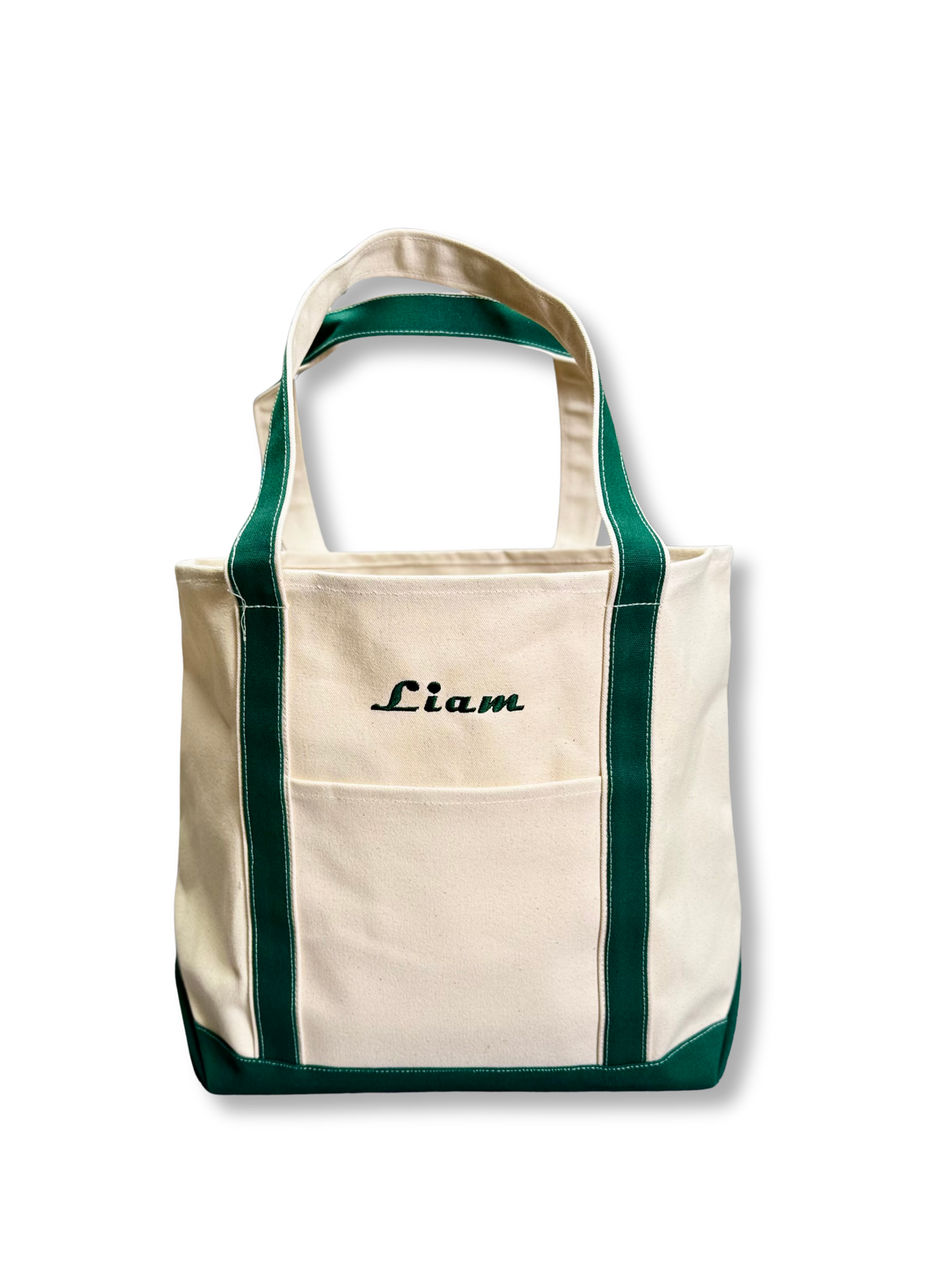 Custom Tote, Superior MI Tote, XL, Open Top, Helmsman Stitch Company. An off-white canvas tote bag with dark green trim and handles, featuring a front pocket and the name 'Liam' embroidered in black script on the upper front. Makes a great gift.