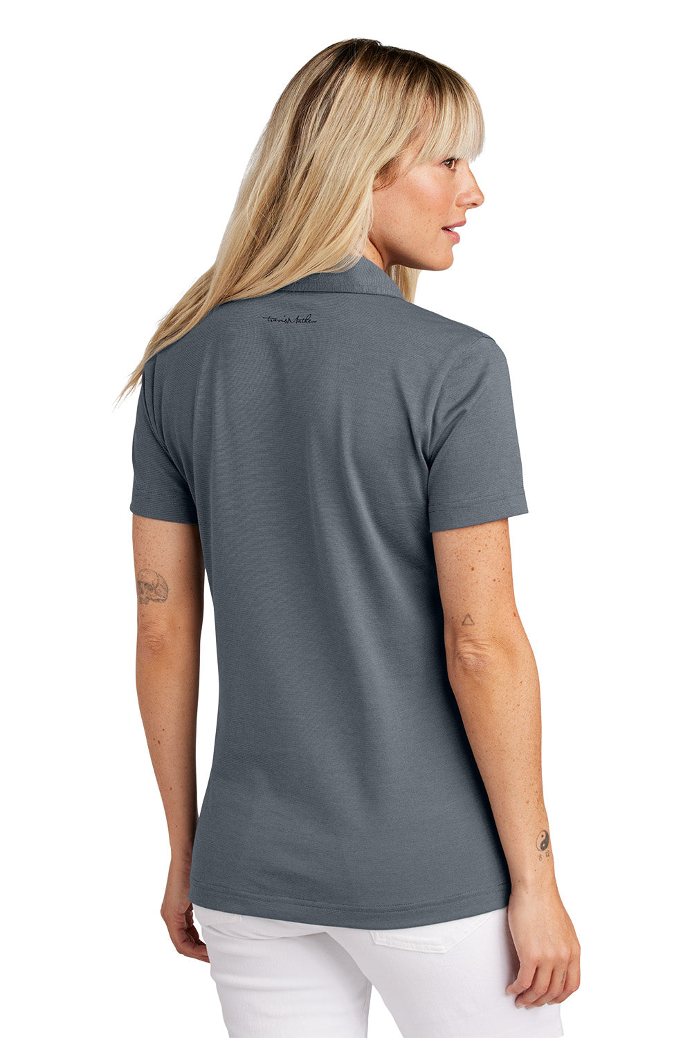 Woman wearing a gray polo shirt with a visible brand logo on the back. Embroidered TravisMathew Women's Sunnyvale Polo