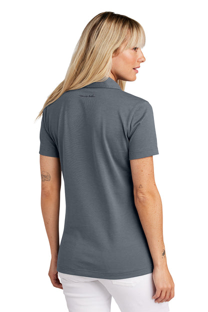 Woman wearing a gray polo shirt with a visible brand logo on the back. Embroidered TravisMathew Women's Sunnyvale Polo