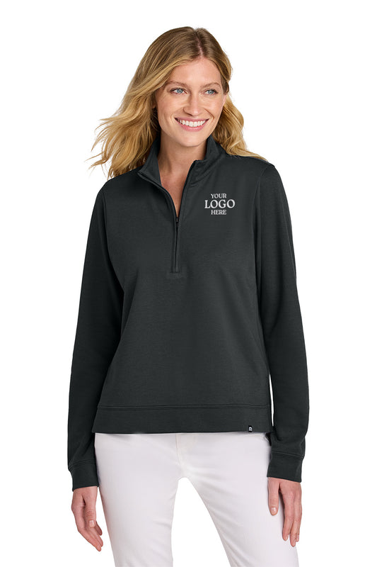 Woman wearing a black pullover with a logo on a white background TravisMathew Women's Coveside 1/2-Zip, Embroidered