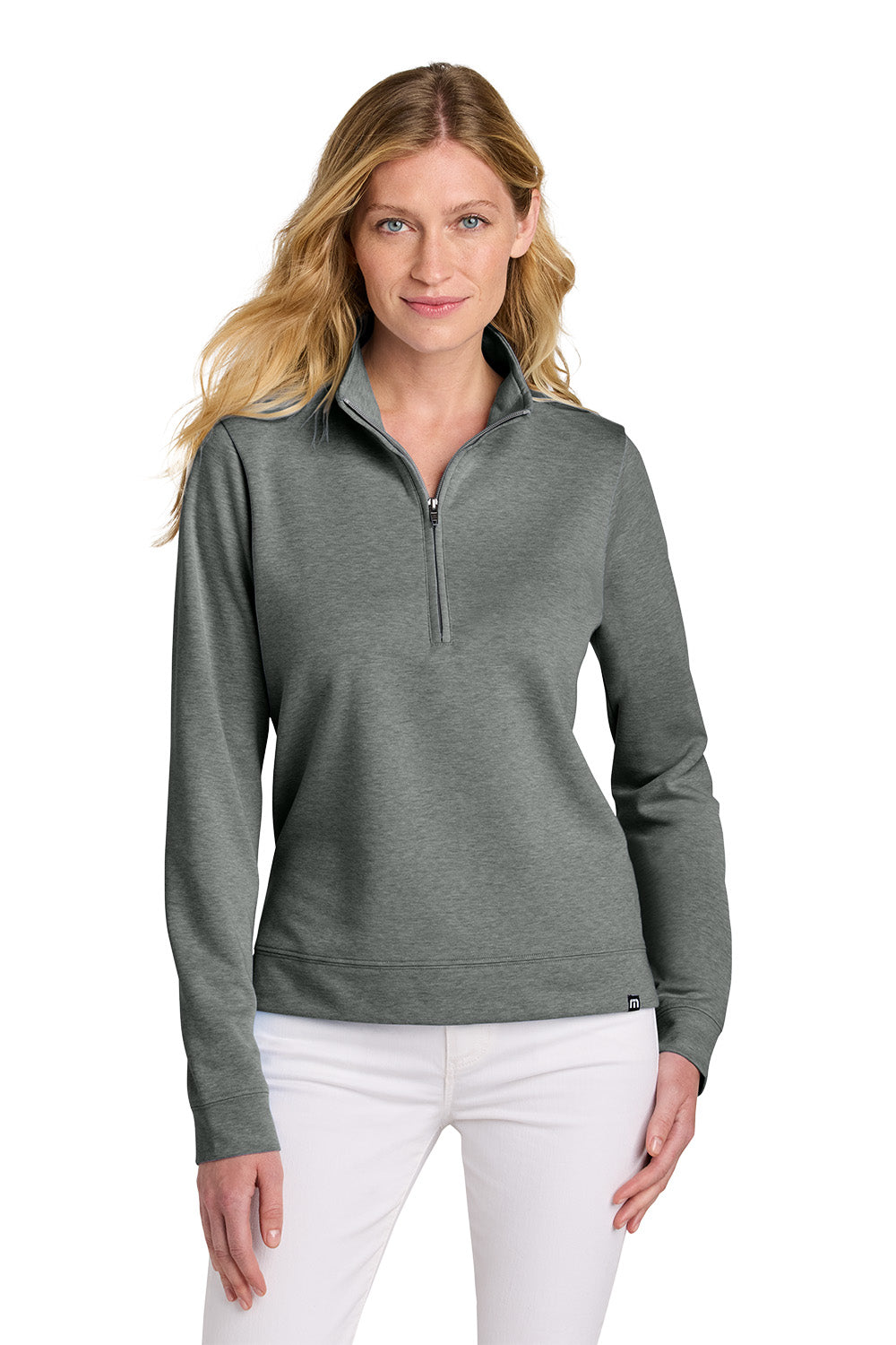 Woman wearing a gray long-sleeve shirt with a quarter zip and white pants on a white background TravisMathew Women's Coveside 1/2-Zip, Embroidered