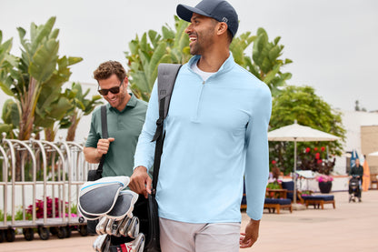 Two men walking outdoors with golf bags, one wearing a light blue shirt and cap. TravisMathew Onward 1/2-Zip, Embroidered