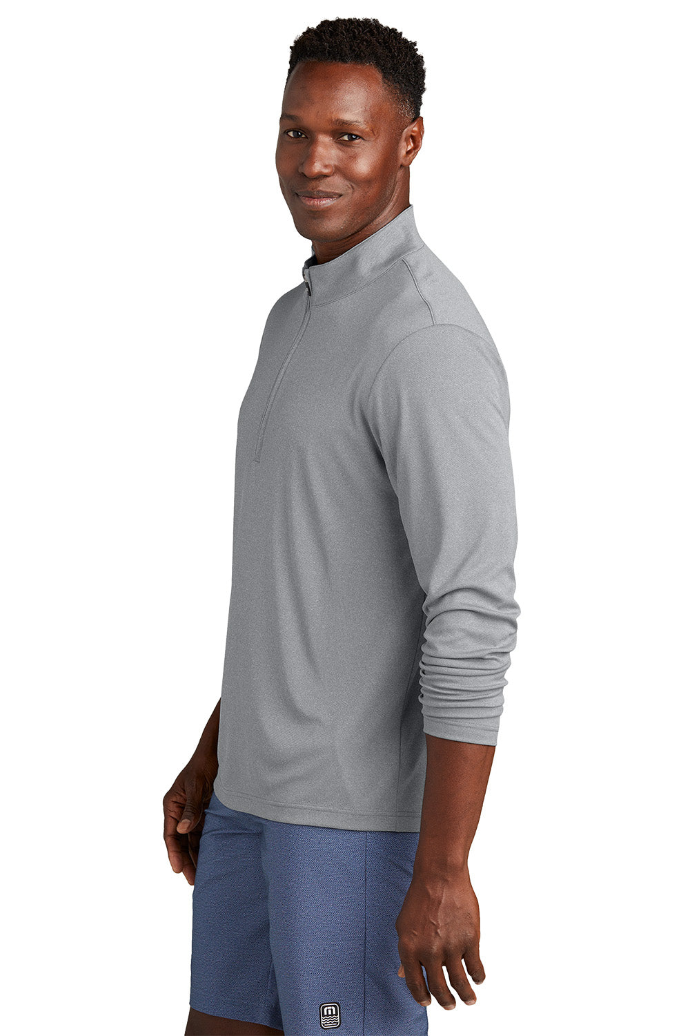 Man wearing a gray long-sleeve athletic shirt and blue shorts on a white background, embroidered TravisMathew Coto Performance 1/4-Zip