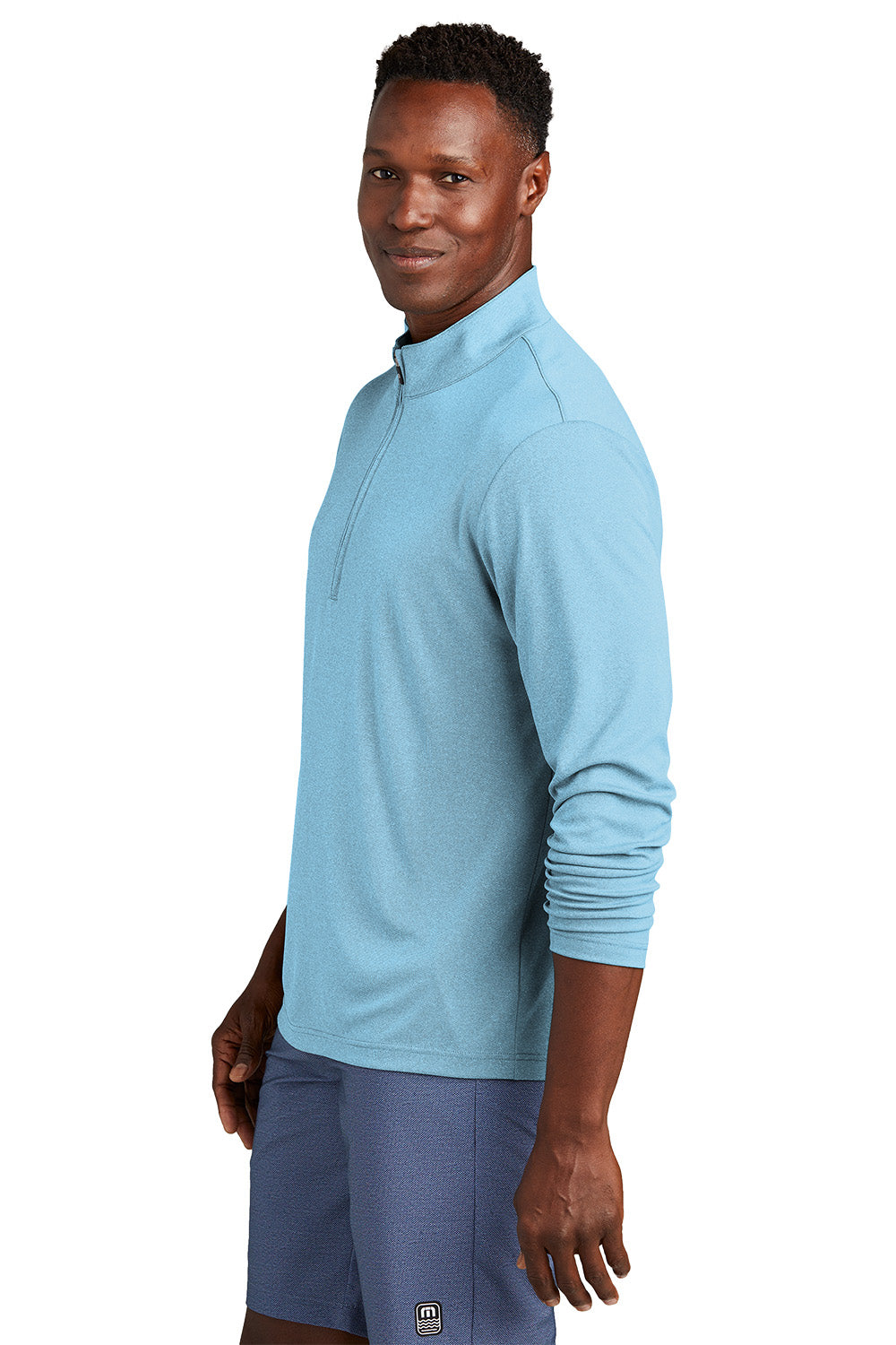 Man wearing a light blue long-sleeve athletic shirt on a white background, embroidered TravisMathew Coto Performance 1/4-Zip