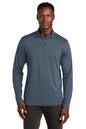 Man wearing a gray long-sleeve shirt with a quarter zip on a white background, embroidered TravisMathew Coto Performance 1/4-Zip