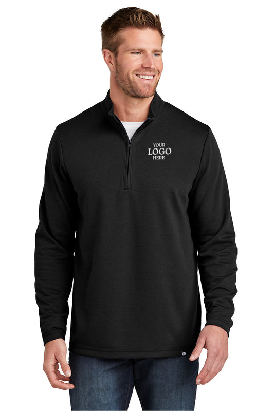 Man wearing a black quarter-zip pullover with customizable text on a white background TravisMathew Coveside 1/4-Zip, Embroidered
