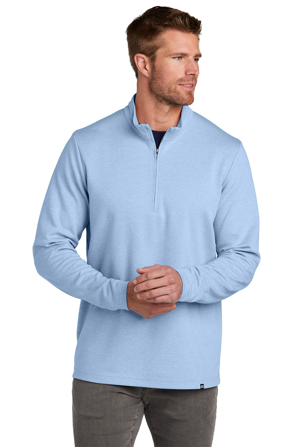 Man wearing a light blue pullover with a quarter zip on a white background TravisMathew Coveside 1/4-Zip, Embroidered