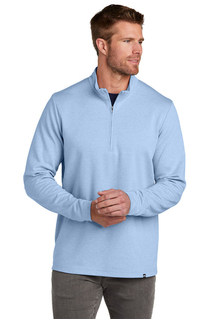 Man wearing a light blue pullover with a quarter zip on a white background TravisMathew Coveside 1/4-Zip, Embroidered