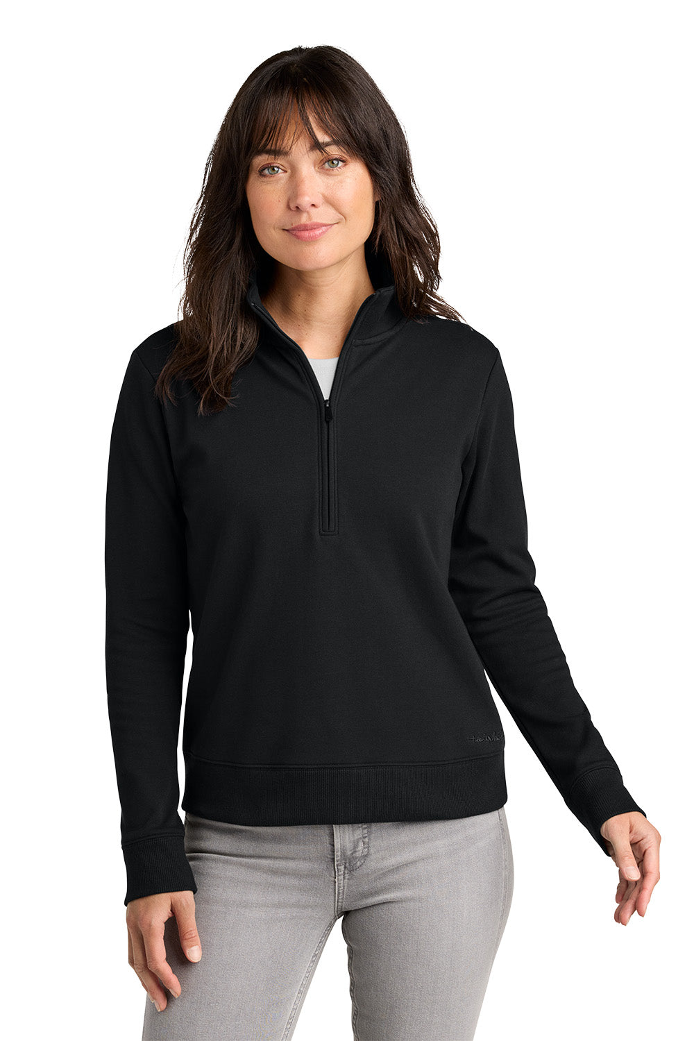 Woman wearing a black long-sleeve shirt with a quarter zip on a white. TravisMathew Women's Ocean Villa 1/4-Zip, Embroidered background