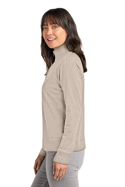 Woman wearing a beige turtleneck sweater on a white background. TravisMathew Women's Ocean Villa 1/4-Zip, Embroidered