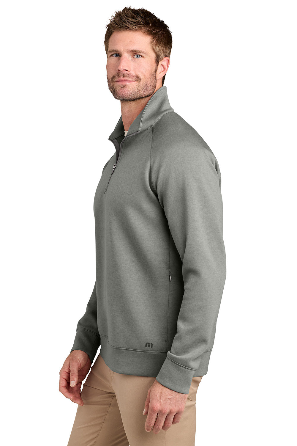 A man wearing a gray quarter-zip pullover sweater and khaki pants, shown from a side profile against a white background. TravisMathew Momentum Shift 1/4-Zip, Embroidered