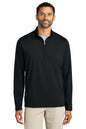 A man wearing a black long-sleeve quarter-zip pullover sweater over a light blue undershirt and beige pants, photographed against a plain white background. TravisMathew Onward 1/2-Zip, Embroidered