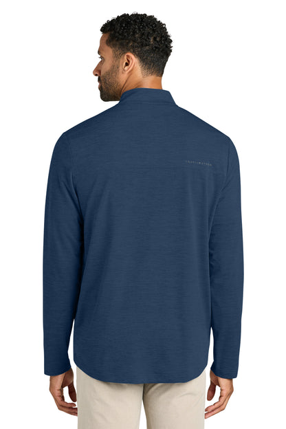 Man wearing a blue long-sleeve shirt with a brand logo on the back, standing against a white background. TravisMathew Onward 1/2-Zip, Embroidered