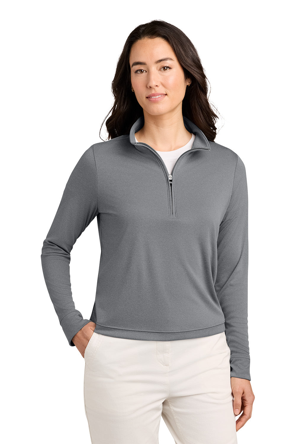 A woman modeling a gray long-sleeve quarter-zip pullover with a stand collar, paired with off-white pants, against a plain white background. TravisMathew Women's Coto Performance 1/2-Zip, Embroidered