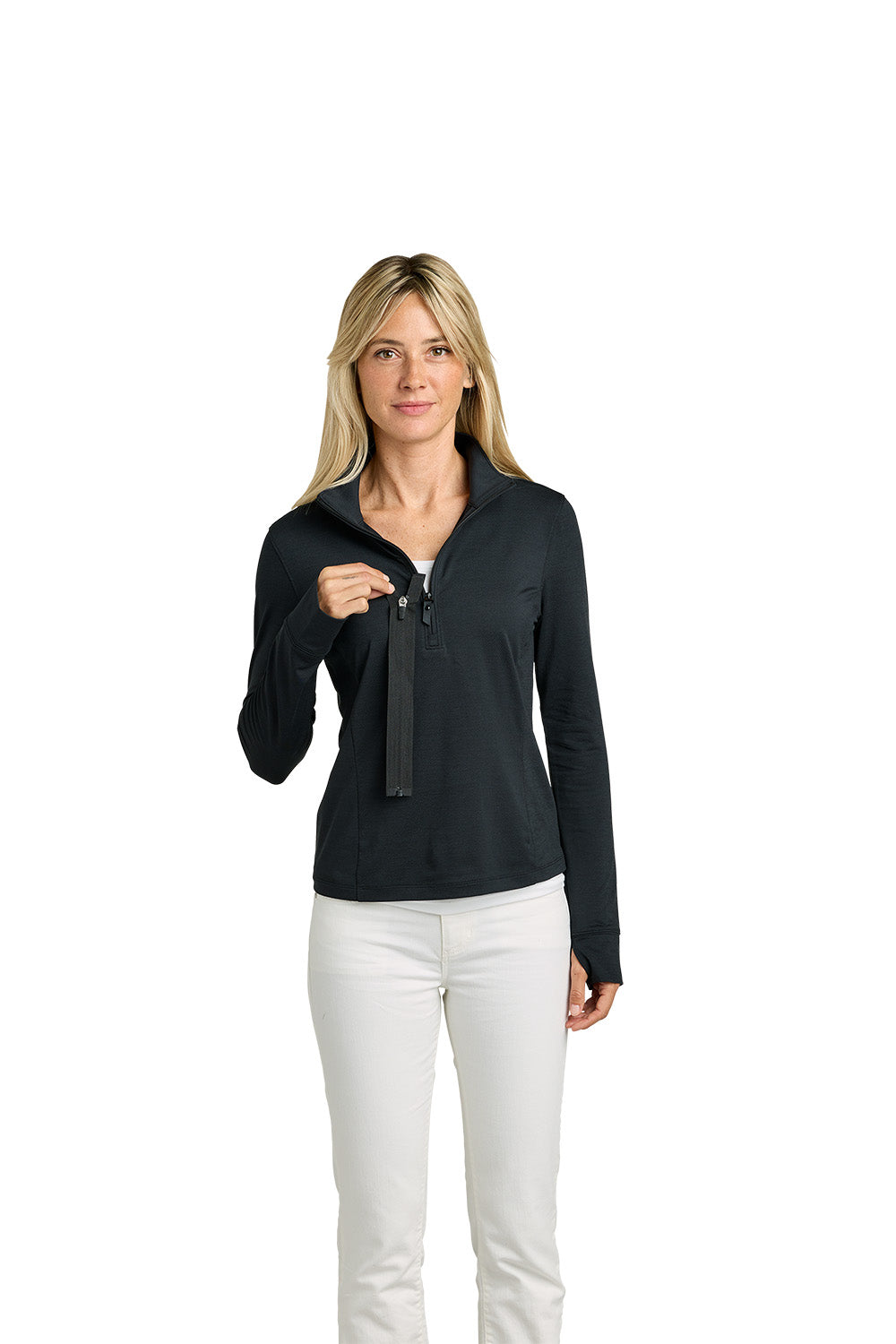 A woman modeling a black long-sleeve half-zip pullover with a split collar, paired with white pants, against a solid white background. TravisMathew Women’s Onward 1/2-Zip, Embroidered