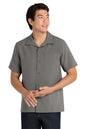 Man wearing a gray short-sleeve button-up shirt on a white background embroidered Port Authority ® Short Sleeve Performance Staff Shirt
