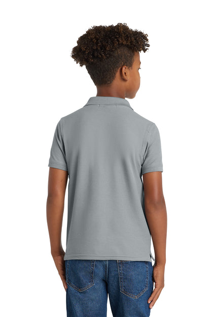 Child wearing a gray polo shirt and blue jeans on a white background. Port Authority® Youth Core Classic Pique Polo, Embroidered by Helmsman Stitch Co.