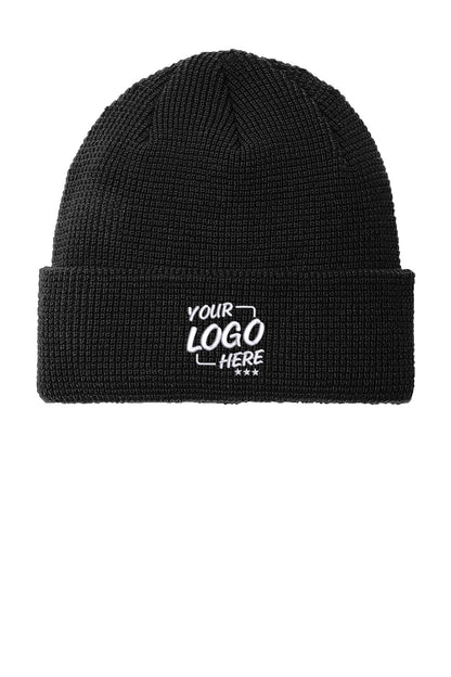 A black ribbed knit beanie hat with a white embroidered placeholder text reading 'YOUR LOGO HERE' on the front cuff, shown against a plain white background. Port Authority® Thermal Knit Cuff Beanie, Embroidered